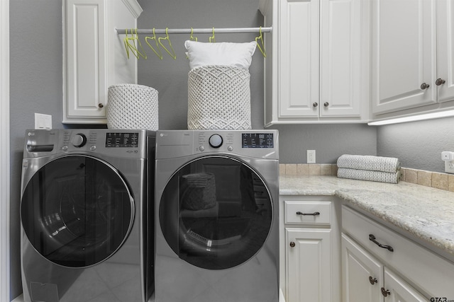 clothes washing area featuring cabinets and independent washer and dryer