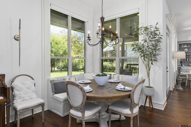 dining space featuring dark hardwood / wood-style floors, an inviting chandelier, and ornamental molding