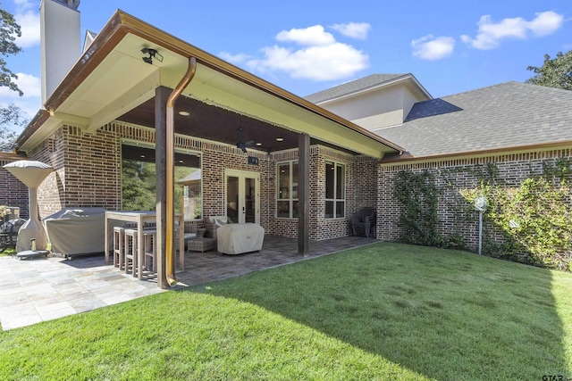 back of property featuring a yard, french doors, and a patio