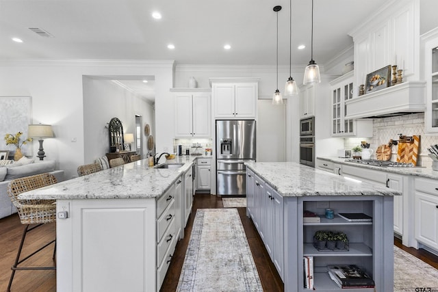 kitchen with a breakfast bar area, white cabinetry, and a center island with sink