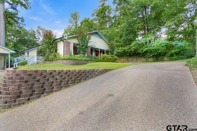 1656 Pineview Ln, Hideaway, TX 75771 - view of front of home featuring brick siding, driveway, and a front lawn