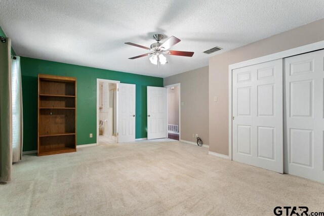 1656 Pineview Ln, Hideaway, TX 75771 - unfurnished bedroom with carpet floors, a textured ceiling, a closet, a ceiling fan, and connected bathroom