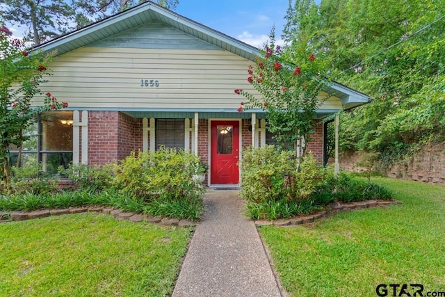 1656 Pineview Ln, Hideaway, TX 75771 - bungalow-style home featuring covered porch, a front lawn, and brick siding