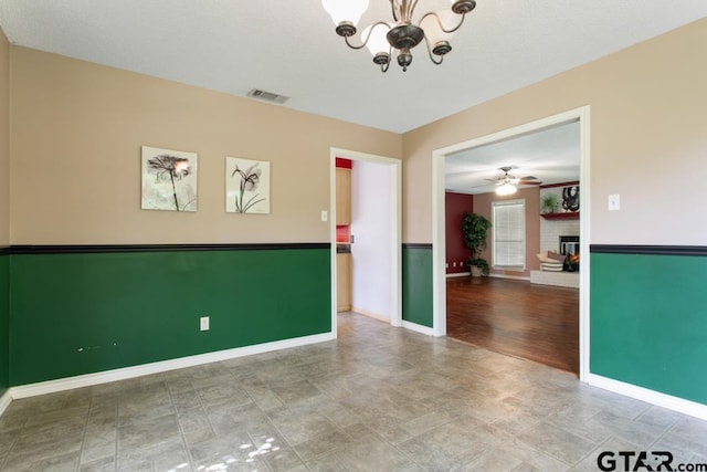 1656 Pineview Ln, Hideaway, TX 75771 - empty room featuring a chandelier, ceiling fan, and stone finish flooring