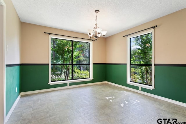 1656 Pineview Ln, Hideaway, TX 75771 - unfurnished room with a chandelier and a textured ceiling