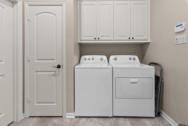 washroom featuring cabinets and independent washer and dryer