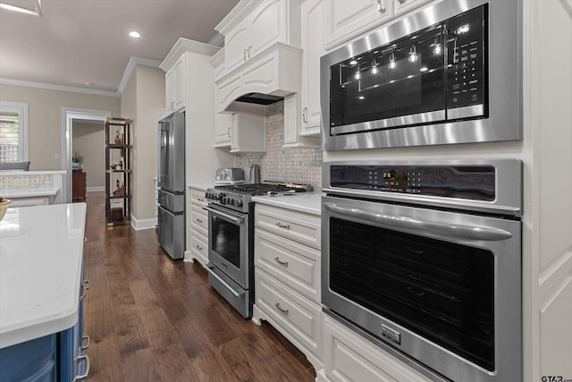 kitchen featuring stainless steel appliances, light stone counters, dark hardwood / wood-style floors, backsplash, and white cabinets