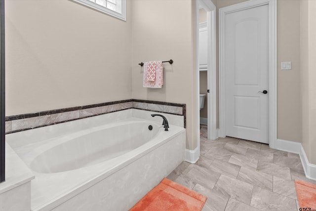 bathroom featuring a washtub and toilet