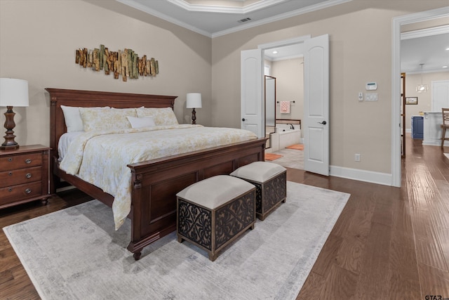 bedroom featuring a raised ceiling, ensuite bathroom, crown molding, and wood-type flooring