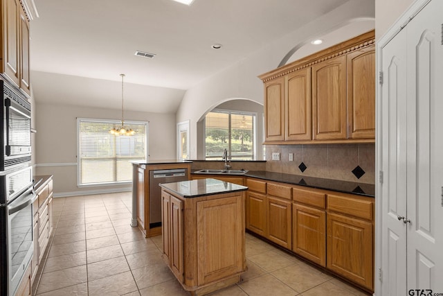 kitchen featuring light tile patterned flooring, appliances with stainless steel finishes, sink, lofted ceiling, and a center island