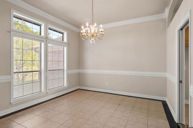 tiled spare room featuring a notable chandelier and crown molding