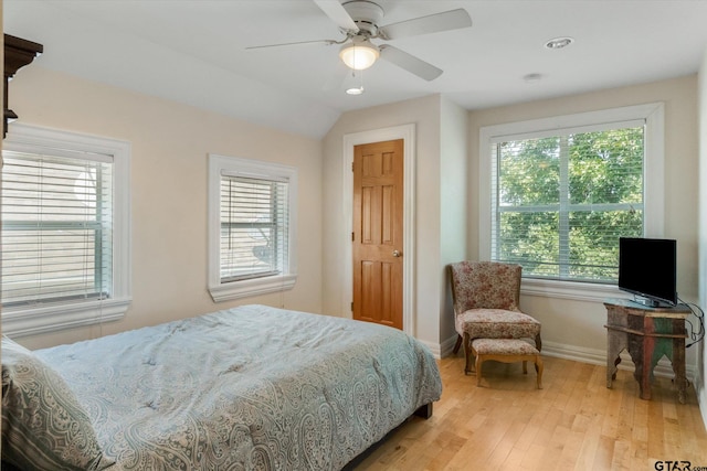 bedroom with light hardwood / wood-style flooring, lofted ceiling, and ceiling fan