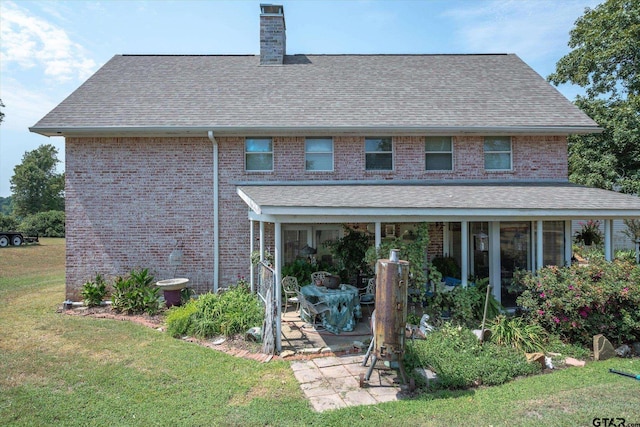 rear view of property featuring a patio and a yard