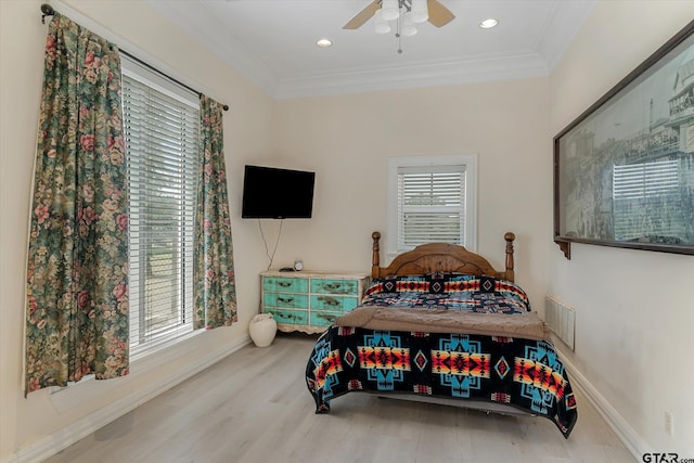 bedroom with ornamental molding, multiple windows, wood-type flooring, and ceiling fan