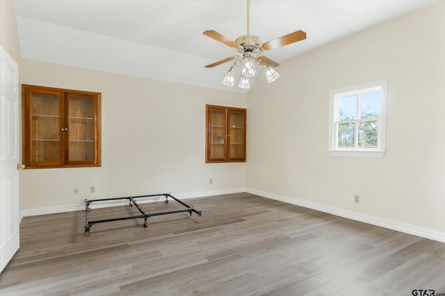 spare room featuring lofted ceiling, ceiling fan, and light hardwood / wood-style flooring