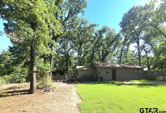 view of yard featuring fence and dirt driveway