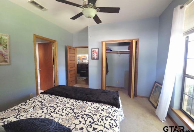 bedroom featuring a ceiling fan, a closet, visible vents, baseboards, and light carpet