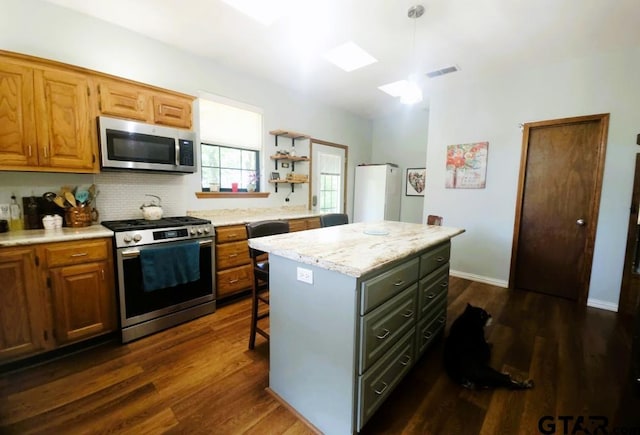 kitchen featuring visible vents, dark wood finished floors, appliances with stainless steel finishes, and a kitchen island