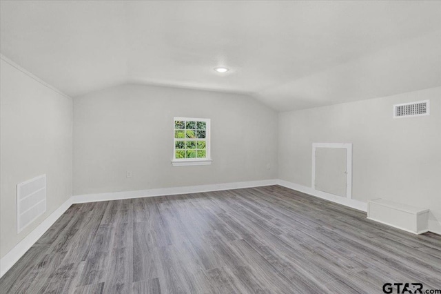 bonus room with hardwood / wood-style flooring and vaulted ceiling