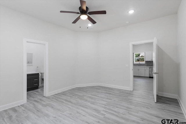 spare room with light hardwood / wood-style flooring, ceiling fan, and sink