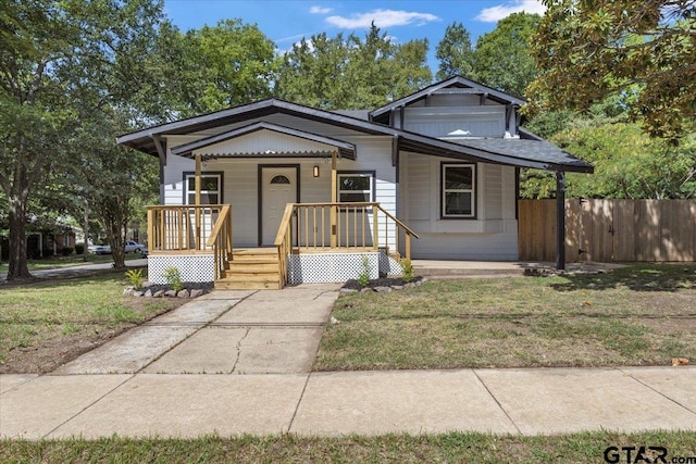 bungalow with a porch and a front lawn