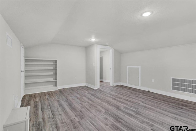 254 SE 19th St, Paris, TX 75460 - bonus room featuring vaulted ceiling, wood finished floors, a textured ceiling, baseboards, and built in shelves