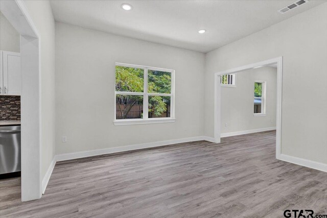 unfurnished living room featuring light wood-type flooring and a wealth of natural light