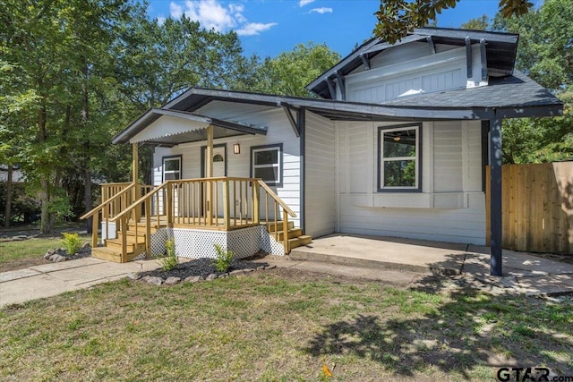 bungalow with a porch and a front lawn