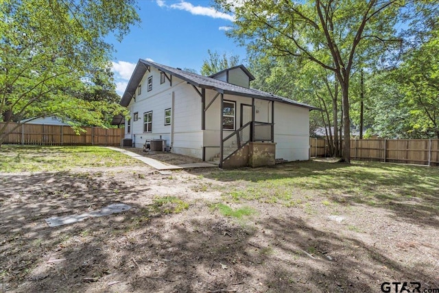 exterior space with central AC and a yard