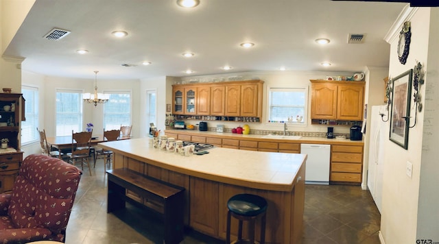 kitchen with plenty of natural light, sink, pendant lighting, and white appliances