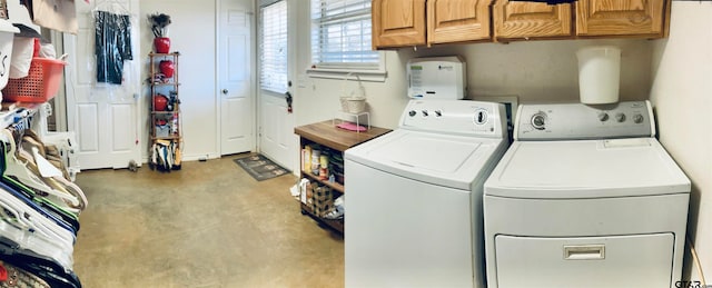 laundry room featuring washer and dryer and cabinets