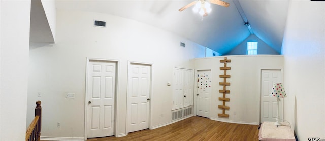 interior space with wood-type flooring, high vaulted ceiling, and ceiling fan