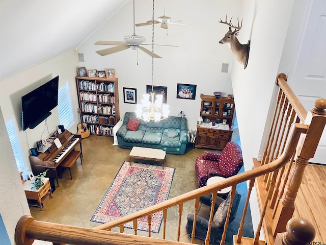 living room with ceiling fan with notable chandelier, wood-type flooring, crown molding, and high vaulted ceiling