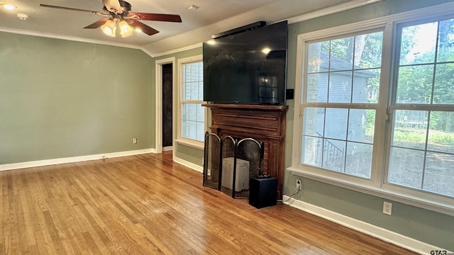 1012 W 8th St, Tyler, TX 75701 - unfurnished living room with ornamental molding, baseboards, ceiling fan, and wood finished floors