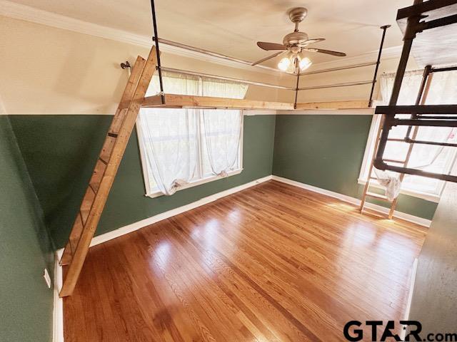 1012 W 8th St, Tyler, TX 75701 - unfurnished bedroom with crown molding, wood finished floors, and baseboards