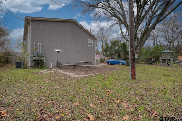 view of property exterior with central AC unit and a yard