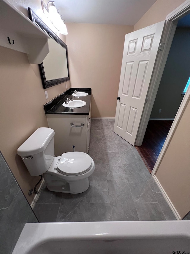 bathroom with toilet, vanity, and hardwood / wood-style flooring