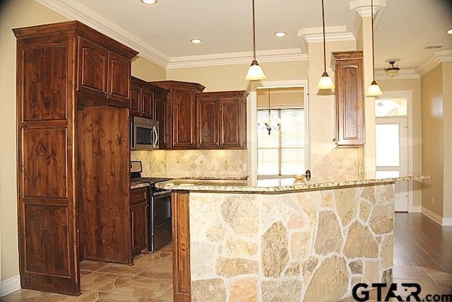 kitchen featuring a kitchen island, appliances with stainless steel finishes, pendant lighting, and light stone counters