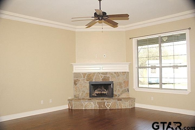 unfurnished living room with ornamental molding, a stone fireplace, dark wood-type flooring, and baseboards