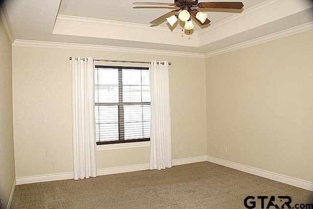 carpeted empty room with baseboards, a raised ceiling, a ceiling fan, and crown molding