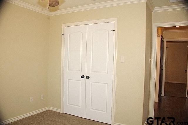 unfurnished bedroom featuring ornamental molding, carpet, a closet, and baseboards