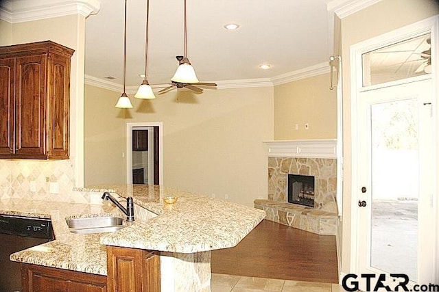 kitchen with decorative backsplash, dishwasher, ornamental molding, light stone counters, and a sink