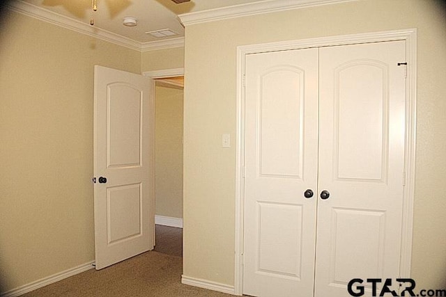 unfurnished bedroom with carpet floors, ornamental molding, a closet, and baseboards