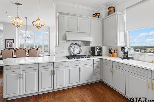 2801 Wexford Dr, Tyler, TX 75709 - kitchen with a chandelier, stainless steel gas stovetop, healthy amount of natural light, custom exhaust hood, and ornamental molding