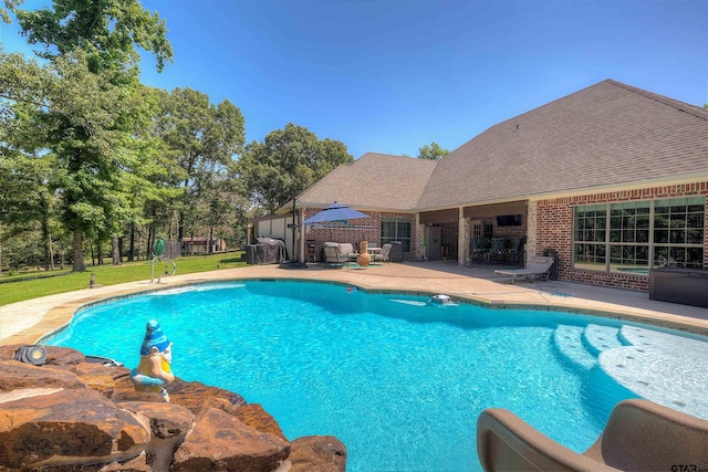 view of pool featuring a patio area and a yard