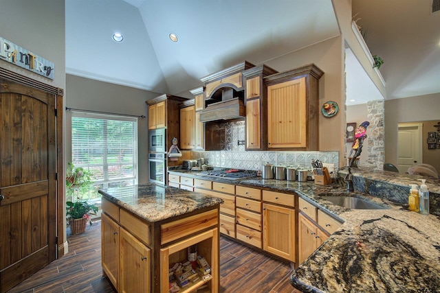 kitchen with dark stone counters, sink, kitchen peninsula, backsplash, and stainless steel appliances