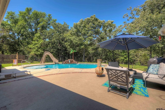 view of swimming pool with area for grilling, a patio area, and a water slide