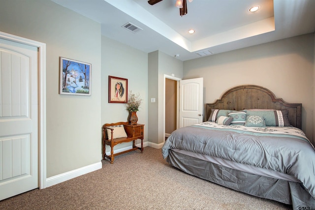 bedroom with carpet, ceiling fan, and a raised ceiling