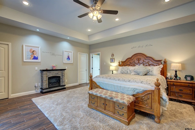 bedroom with ceiling fan and a fireplace