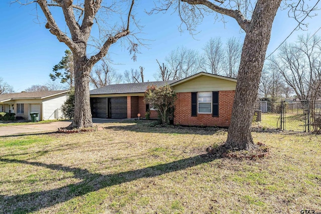 view of front facade featuring a front yard, fence, driveway, a garage, and brick siding